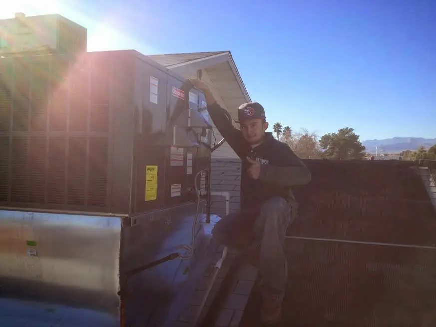 HVAC technician performing Boiler Repair on a rooftop unit in Corinth